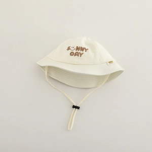 Detailed close-up of cream baby sun hat featuring SUNNY DAY embroidery and adjustable chin strap