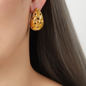 Minimalist gold teardrop earrings with woven texture design shown on a model