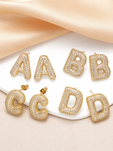 Close-up of gold-plated letter earrings A, B, C, D with sparkling cubic zirconia inlay