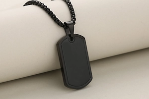 Close-up of a minimalist black stainless steel military dog tag pendant with a matching chain