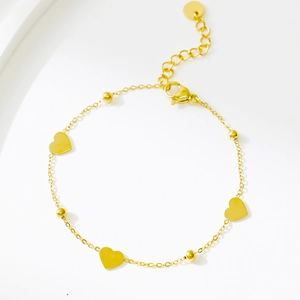Close-up of gold stainless steel heart bracelet with charms and lobster clasp