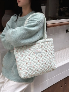 Close-up of diamond quilted mint green tote bag with small cartoon animal prints