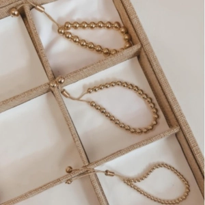 Adjustable gold plated bead bracelets with drawstring slide clasp in jewelry organizer
