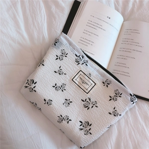 Detail of floral waffle fabric pouch with Time to Party label on white linen