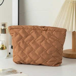 Close-up of brown quilted cosmetic bag texture with neat stitching in a lifestyle setting