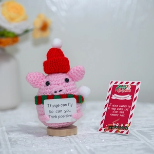 Detail of pink crochet pig with Christmas hat, scarf, and inspirational quote card