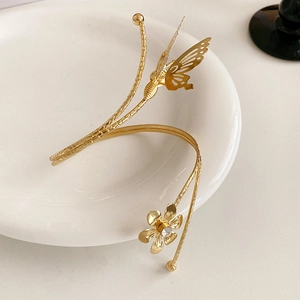 Close-up of golden butterfly and flower bracelet with sparkling white zircon stones