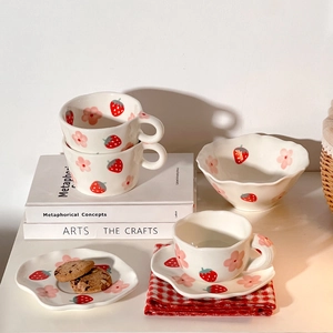 Cute ceramic tea set with hand-painted strawberry and flower patterns on white surface