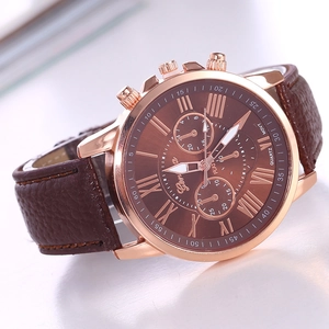 Close-up of Geneva brown leather watch with rose gold case and Roman numeral dial details