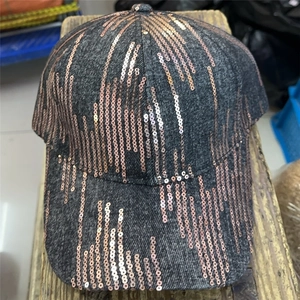 Close-up of baseball cap featuring vertical rose gold sequins on dark grey denim fabric