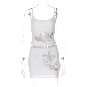 Detail of white two-piece set featuring pink rhinestone floral patterns on fabric