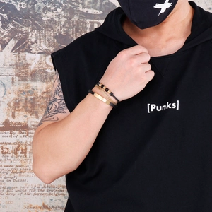 Close-up of men's multi-layer punk bracelet set with black leather and gold metal accents