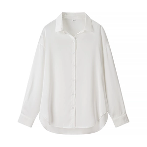 Détail d'une élégante chemise blanche en satin à manches longues avec col à revers brillant