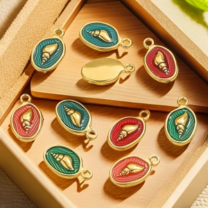 Detailed macro view of colorful enamel conch charms in a rustic wooden tray for DIY jewelry