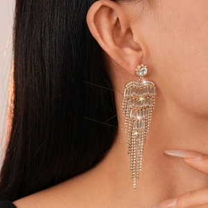 Vue détaillée de longues boucles d'oreilles dorées à pampilles en cristaux de zircon