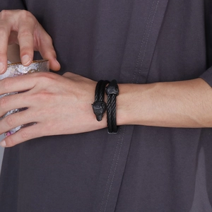 Close-up of black wolf head cable wire bracelet worn by a male model on wrist