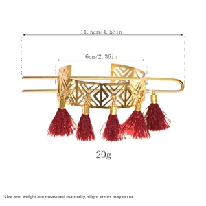 Detail view of vintage gold hollow hair cuff with five dark red tassel pendants and pin