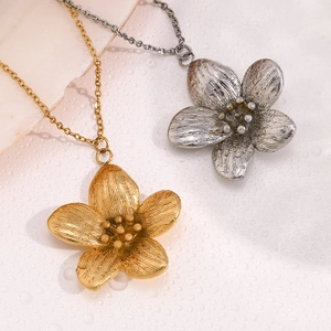 Vue détaillée des pendentifs fleurs dorés et argentés avec texture métal brossé