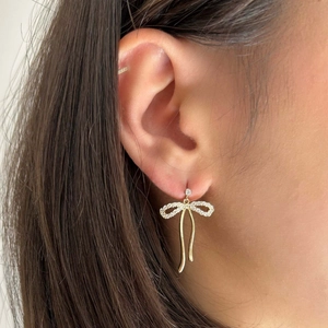 Elegante goldene Schleifenohrringe mit Kristallen am Model, luxuriöser Schlangenstil