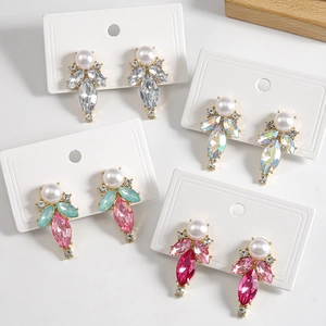 Detail view of pear-shaped drop earrings with micro-set pearls and colorful rhinestones