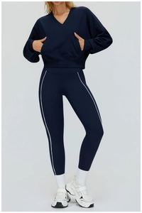 Detail of navy blue V-neck hoodie and striped leggings sports set on a model