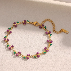 Détail du bracelet plaqué or 18 carats avec breloques cerise mauves et poinçon K18