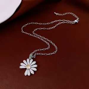 Luxury daisy flower pendant necklace with diamonds and green leaf on deep red velvet