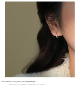 Close-up of elegant S925 silver hoop earrings with sparkling zircon stones on model