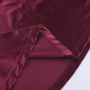 Détail macro du tissu en velours bordeaux montrant des coutures de qualité et un drapé élégant