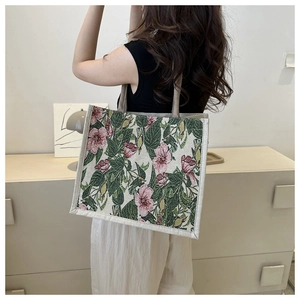 Detail view of woven tote bag featuring vintage pink floral patterns and fabric handle