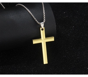 Detailed view of polished golden cross pendant on a silver box chain with black background