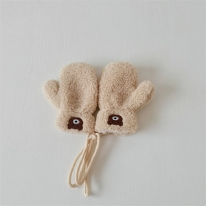 Detail of beige fleece baby mittens with cute bear embroidery and anti-loss string