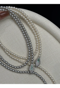 Close-up of multi-layer pearl necklace with luxury serpent-head diamond-set clasp