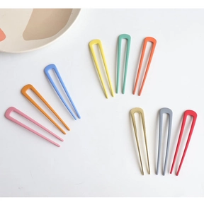 Flat lay of U-shaped metal hairpins in vibrant candy colors and matte finish texture