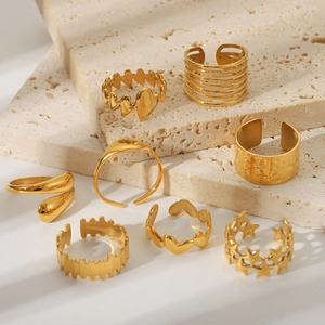 Detailed view of 8pcs set gold 18K plated stainless steel rings on beige stone
