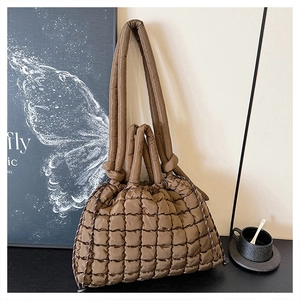 Detail of coffee brown quilted puffer tote bag showing soft down cotton texture and knots