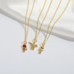 Elegant gold-plated necklaces with bear, turtle and ruby pendants on silk