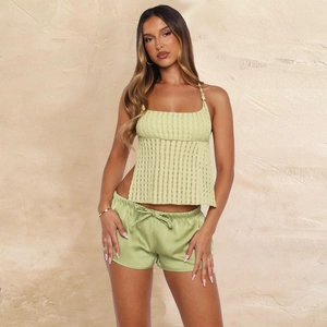 Detail shot of pale green hollow textured camisole and matching satin drawstring shorts