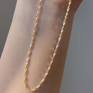 Minimalist gold twisted water wave chain necklace shown on neck with elegant texture