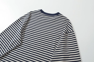 Detailed view of the crew neck and fine blue and white striped fabric texture