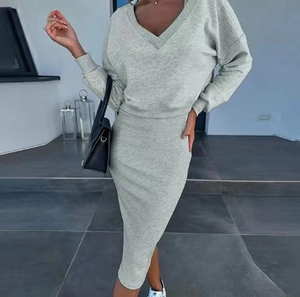 Detail of grey knitted two-piece set featuring a V-neck sweater and fitted midi skirt