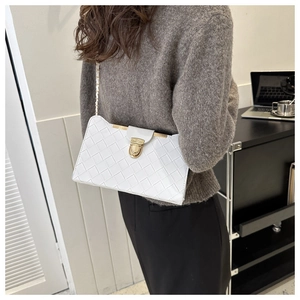 Close-up of white woven shoulder bag featuring gold chain strap and metallic lock detail