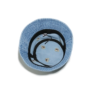 Detail of denim bucket hat interior featuring bear embroidery and adjustable drawstring