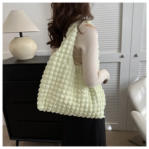 Détail du sac à bandoulière vert clair avec texture gaufrée et design plissé