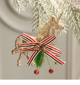 Golden glitter unicorn ornament with pine cones on snow-covered Christmas tree branch
