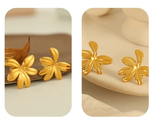 Macro detail of 18K gold plated floral leaf stud earrings with shiny metal texture