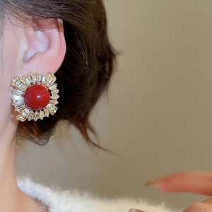 Macro shot of a vintage French-style earring featuring a red center stone and clear zircons