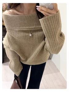 Close-up of pearl pendant necklace styled with khaki off-the-shoulder knit sweater