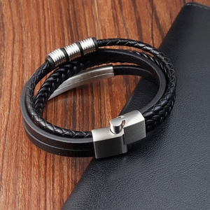 Macro detail of men's multi-layer braided leather bracelet with silver magnetic metal clasp