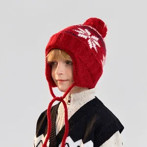 Winter knit hat for kids with red pom-pom and white snowflake pattern earflaps